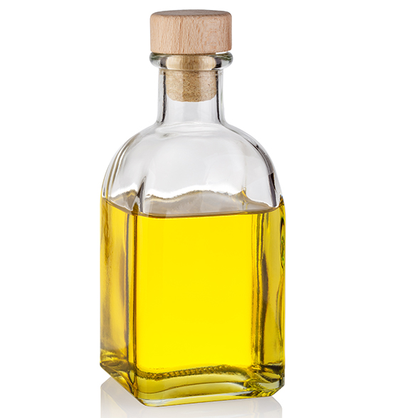 Bottle of yellow oil with a wooden cork isolated on white background